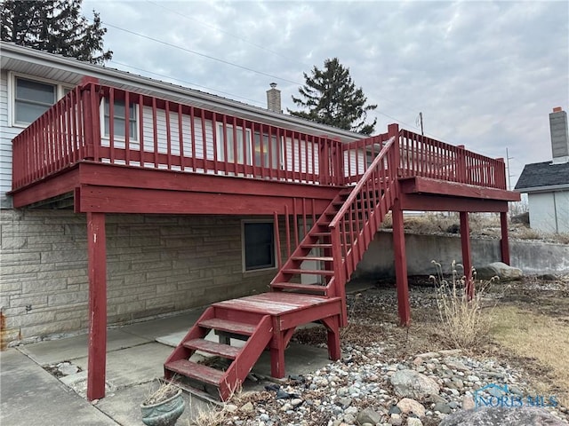 back of property with stairs, a chimney, and a wooden deck