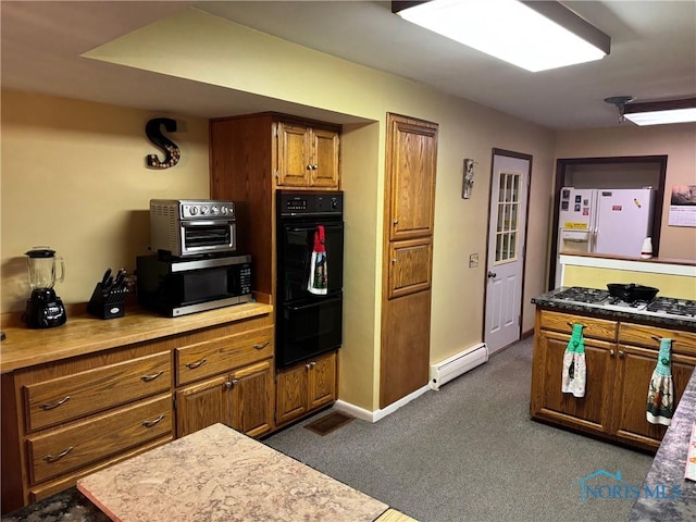 kitchen featuring white appliances, baseboards, brown cabinets, baseboard heating, and dark colored carpet