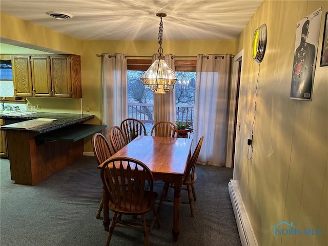 dining area with visible vents, a baseboard heating unit, and dark colored carpet