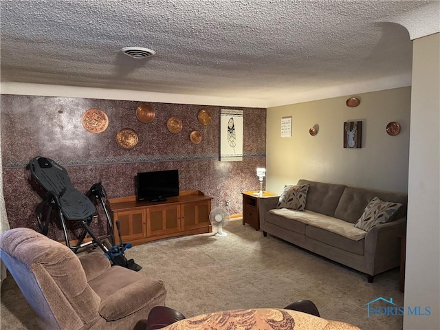 living room with visible vents, carpet flooring, and a textured ceiling