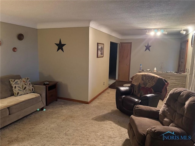 living room featuring track lighting, carpet flooring, a textured ceiling, and baseboards