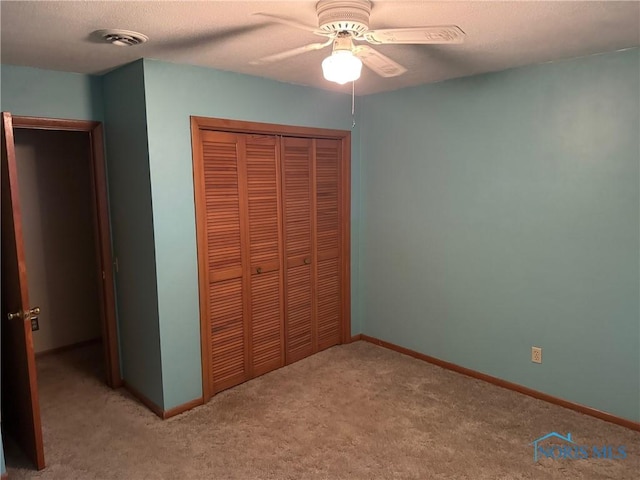 unfurnished bedroom featuring carpet floors, a ceiling fan, baseboards, and a closet