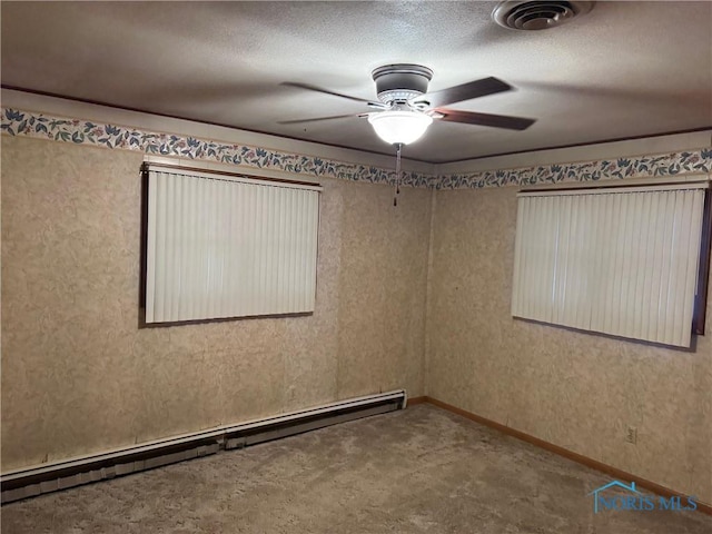 spare room featuring a ceiling fan, a baseboard radiator, visible vents, and a textured ceiling