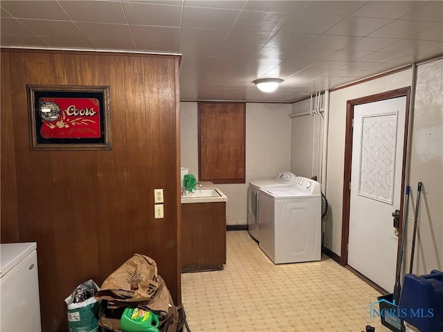 laundry area featuring a sink, laundry area, separate washer and dryer, and light floors