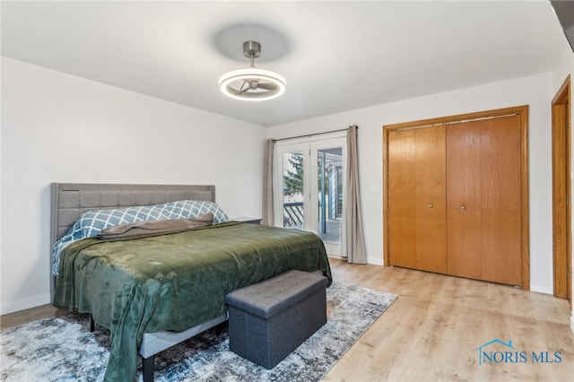 bedroom featuring baseboards, wood finished floors, and access to exterior