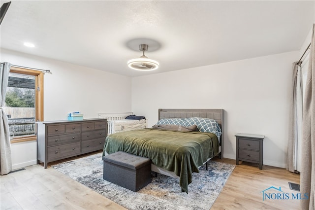 bedroom featuring baseboards, visible vents, and wood finished floors