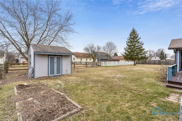 view of yard featuring a fenced backyard, an outdoor structure, and a storage shed