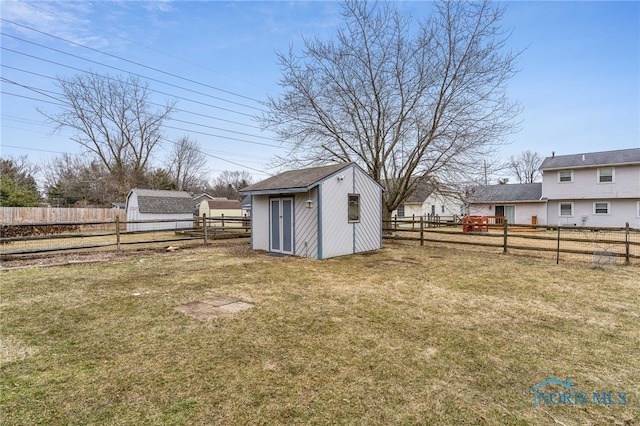 view of yard with a fenced backyard, an outdoor structure, and a storage unit