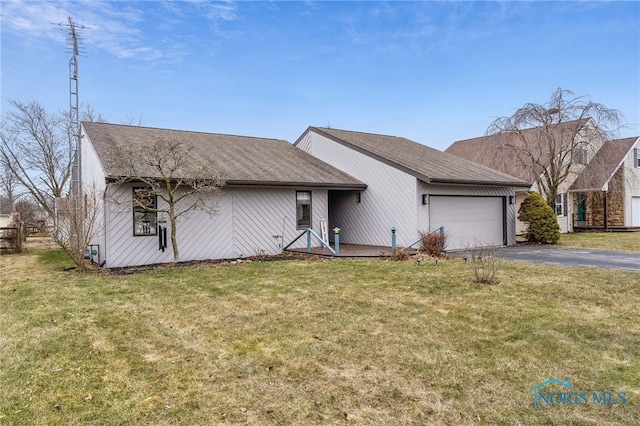 view of front of house with a garage, aphalt driveway, and a front yard