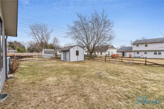 view of yard featuring an outbuilding, a fenced backyard, and a storage shed