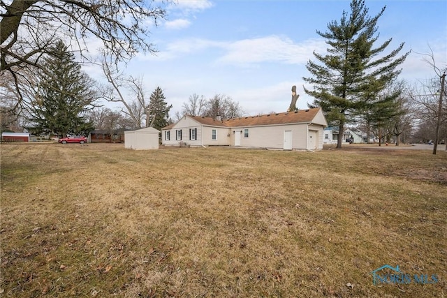 rear view of property with a garage and a lawn