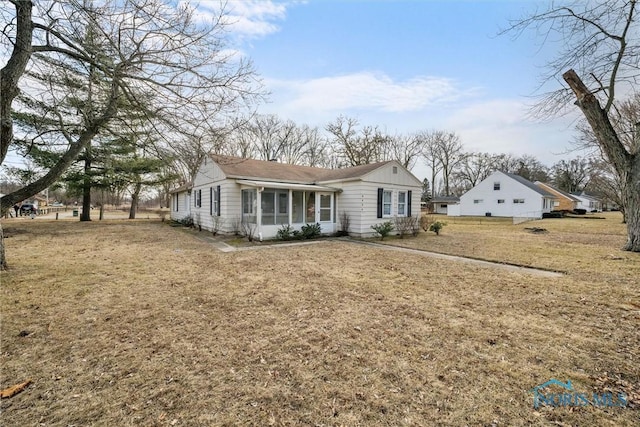 view of front of house with a sunroom and a front lawn