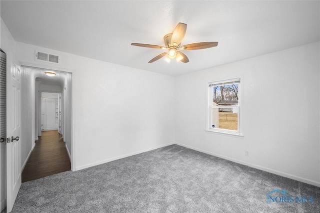 spare room featuring ceiling fan, carpet, visible vents, and baseboards