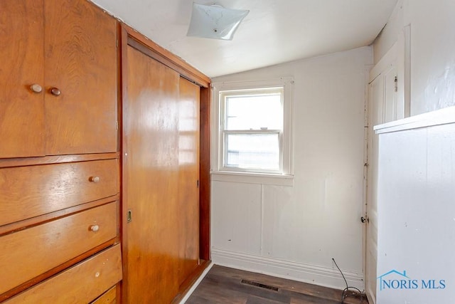 unfurnished bedroom with dark wood-type flooring and visible vents