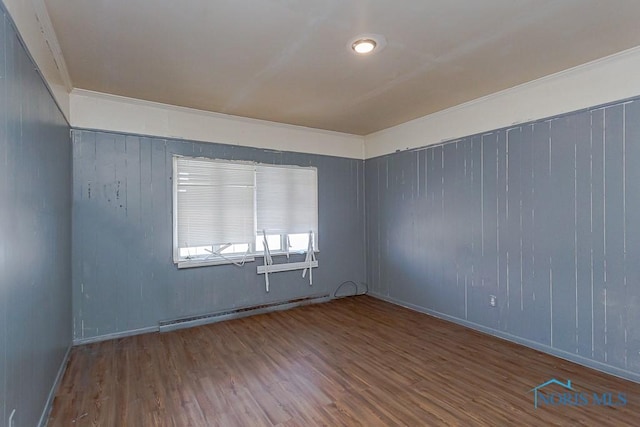 unfurnished room with a baseboard radiator and wood finished floors