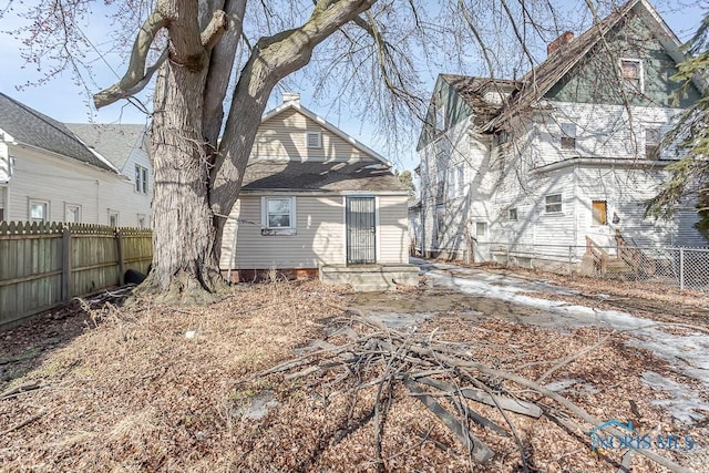 rear view of property featuring fence