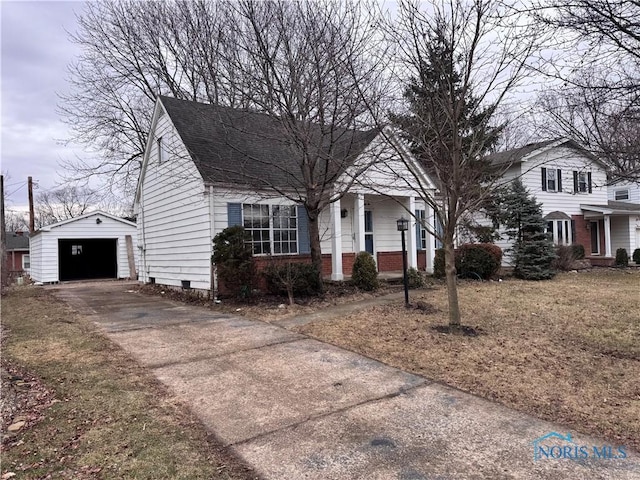 view of front of house featuring driveway, a shingled roof, a detached garage, an outdoor structure, and brick siding