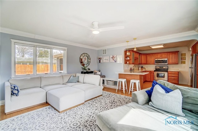 living area with ceiling fan, visible vents, baseboards, light wood-type flooring, and crown molding