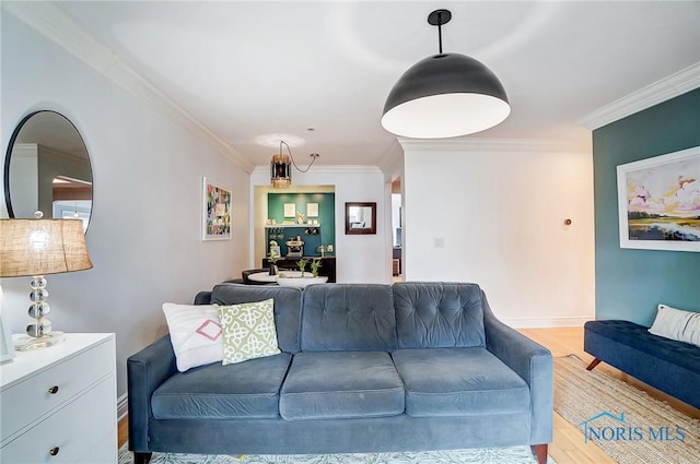 living area with crown molding, light wood-style flooring, and baseboards