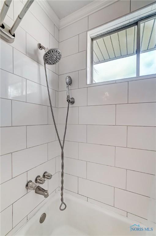 bathroom featuring  shower combination and crown molding