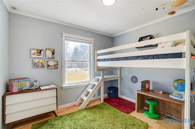 bedroom with baseboards, wood finished floors, and ornamental molding