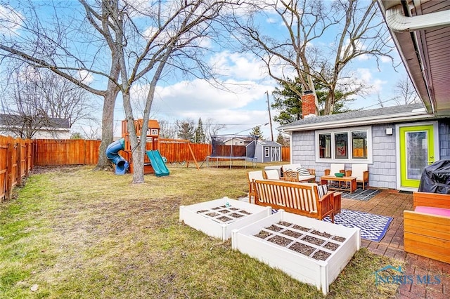 view of yard featuring a playground, a fenced backyard, an outdoor hangout area, a vegetable garden, and a trampoline