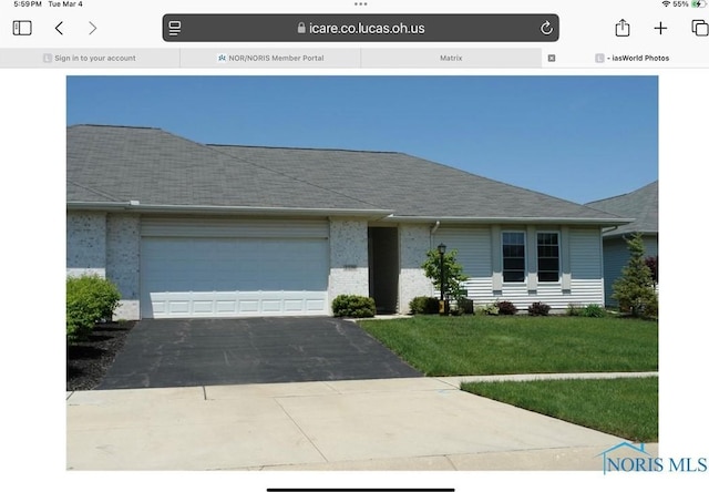 view of front of house with a garage, brick siding, a shingled roof, driveway, and a front yard