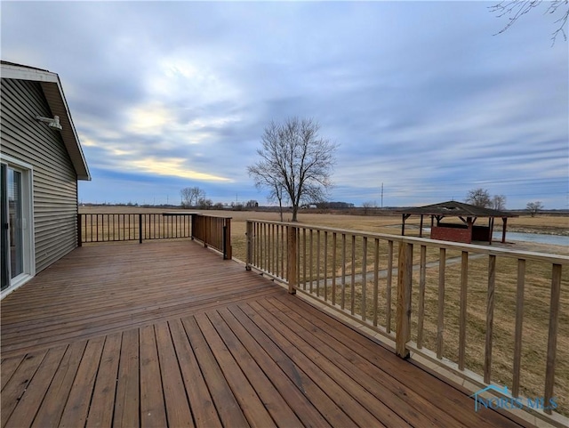 wooden deck with a rural view and a gazebo