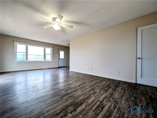 spare room with dark wood-style floors, a textured ceiling, baseboards, and a ceiling fan