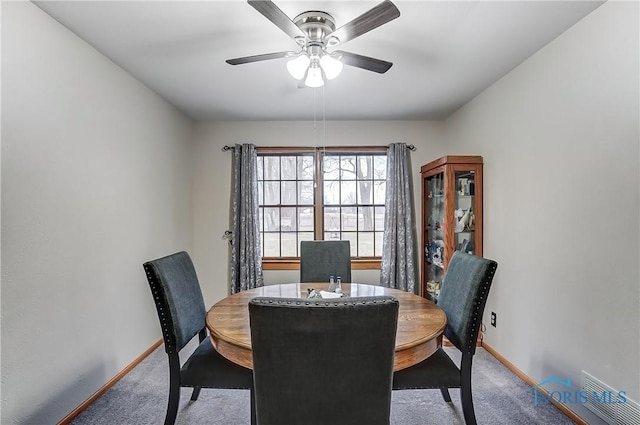 carpeted dining space with visible vents, ceiling fan, and baseboards