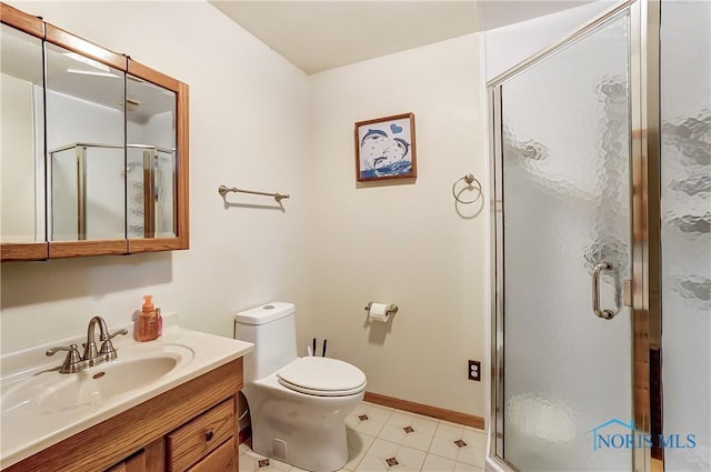 full bath with toilet, a stall shower, baseboards, and vanity