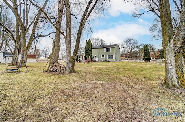 view of yard featuring a playground and fence