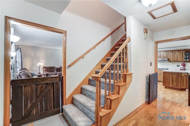 stairway featuring baseboards and wood finished floors