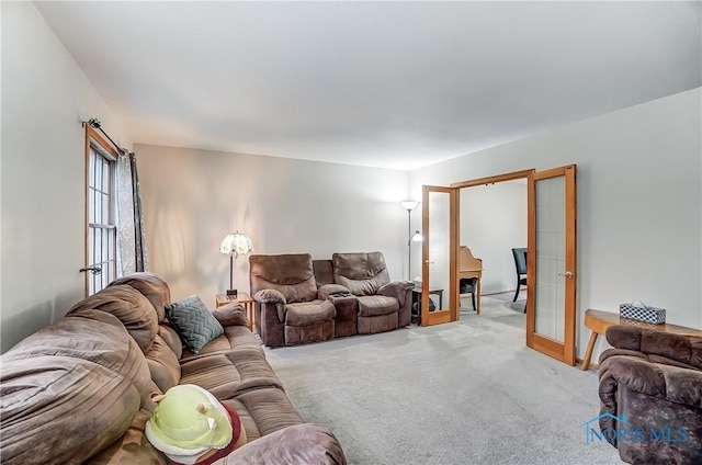 living area featuring french doors and light colored carpet