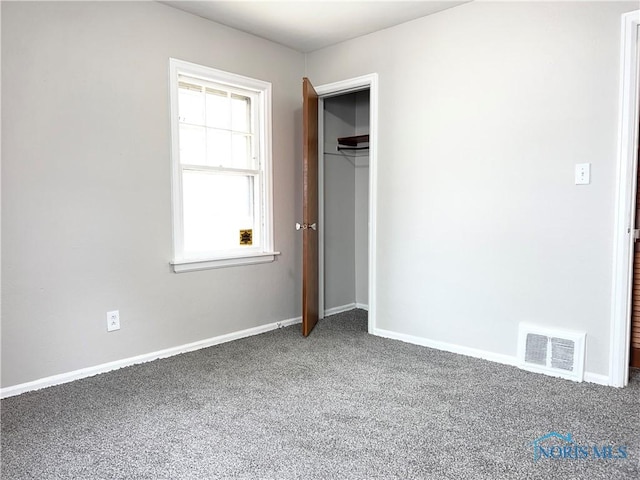 unfurnished bedroom featuring baseboards, a closet, visible vents, and carpet flooring