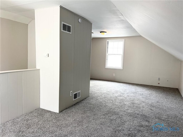 bonus room featuring carpet floors, visible vents, and vaulted ceiling