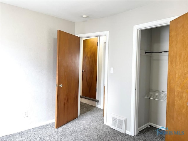 unfurnished bedroom with carpet floors, baseboards, visible vents, and a closet