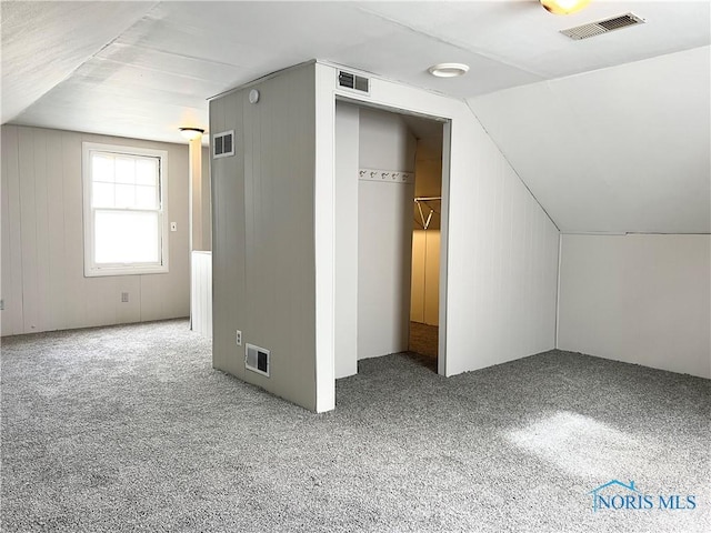 bonus room featuring carpet floors, visible vents, and vaulted ceiling