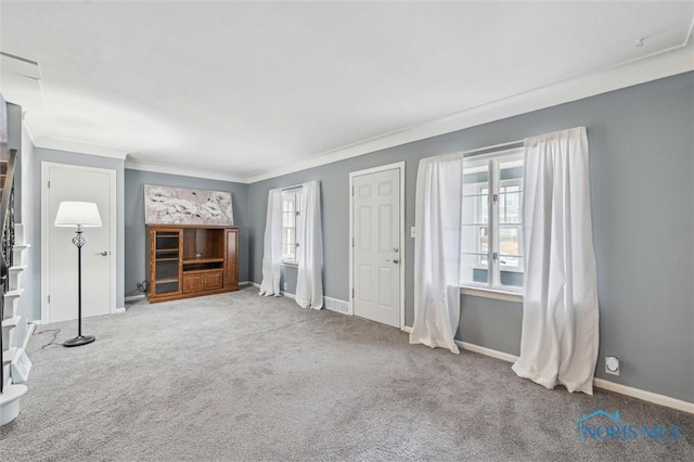 unfurnished living room with baseboards, carpet flooring, and ornamental molding