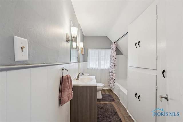 full bathroom featuring toilet, wood finished floors, vaulted ceiling, shower / bath combination with curtain, and vanity