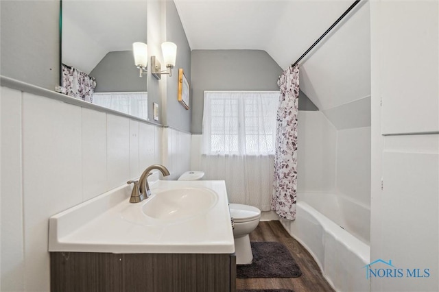 bathroom featuring toilet, shower / bath combo, vaulted ceiling, vanity, and wood finished floors