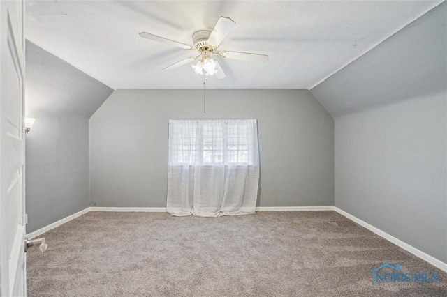 additional living space featuring carpet floors, vaulted ceiling, baseboards, and a ceiling fan