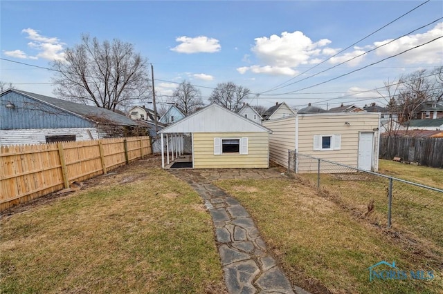 rear view of house featuring a fenced backyard and a lawn