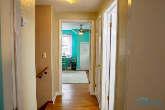 hallway featuring baseboards and wood finished floors