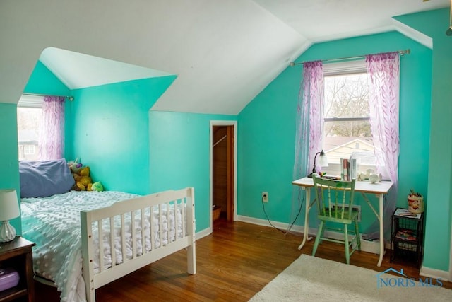 bedroom featuring lofted ceiling, multiple windows, baseboards, and wood finished floors