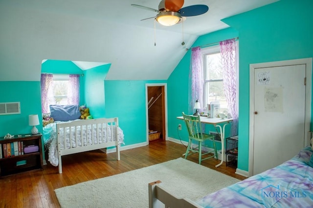 bedroom featuring wood-type flooring, multiple windows, visible vents, and vaulted ceiling