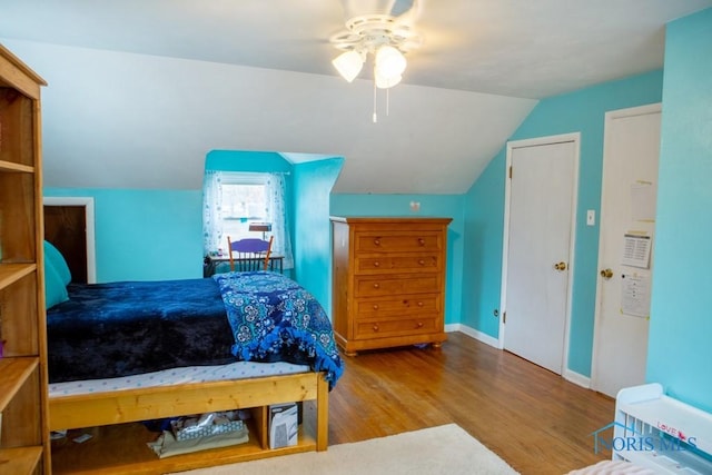 bedroom featuring lofted ceiling, ceiling fan, baseboards, and wood finished floors