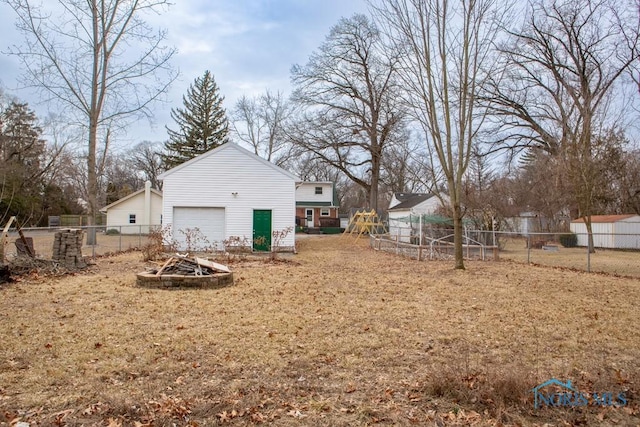 view of yard with a garage, fence, and an outdoor structure