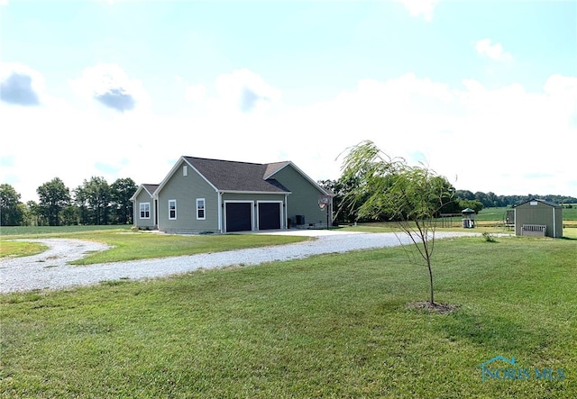 back of house featuring gravel driveway and a yard