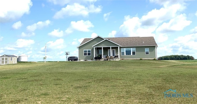 view of front of property with a storage shed, an outdoor structure, and a front yard